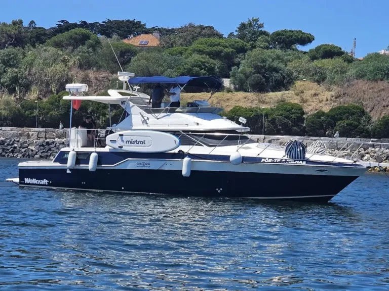Dark classic motor yacht moored beside a stone quay