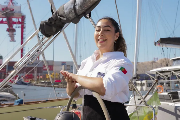 Smiling skipper at the wheel of a sailboat in a marina