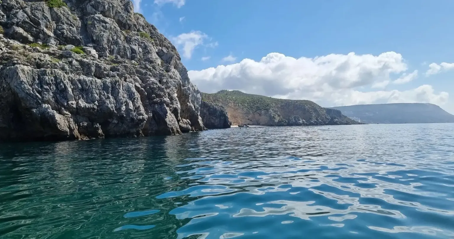 Sea cliffs and a distant headland across rippling water