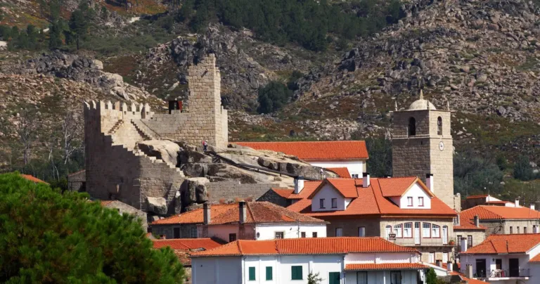 Hilltop castle ruins above village rooftops and a church tower