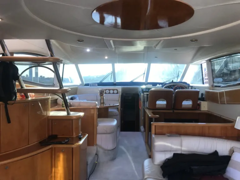 Interior of a yacht saloon with wood panelling and the helm