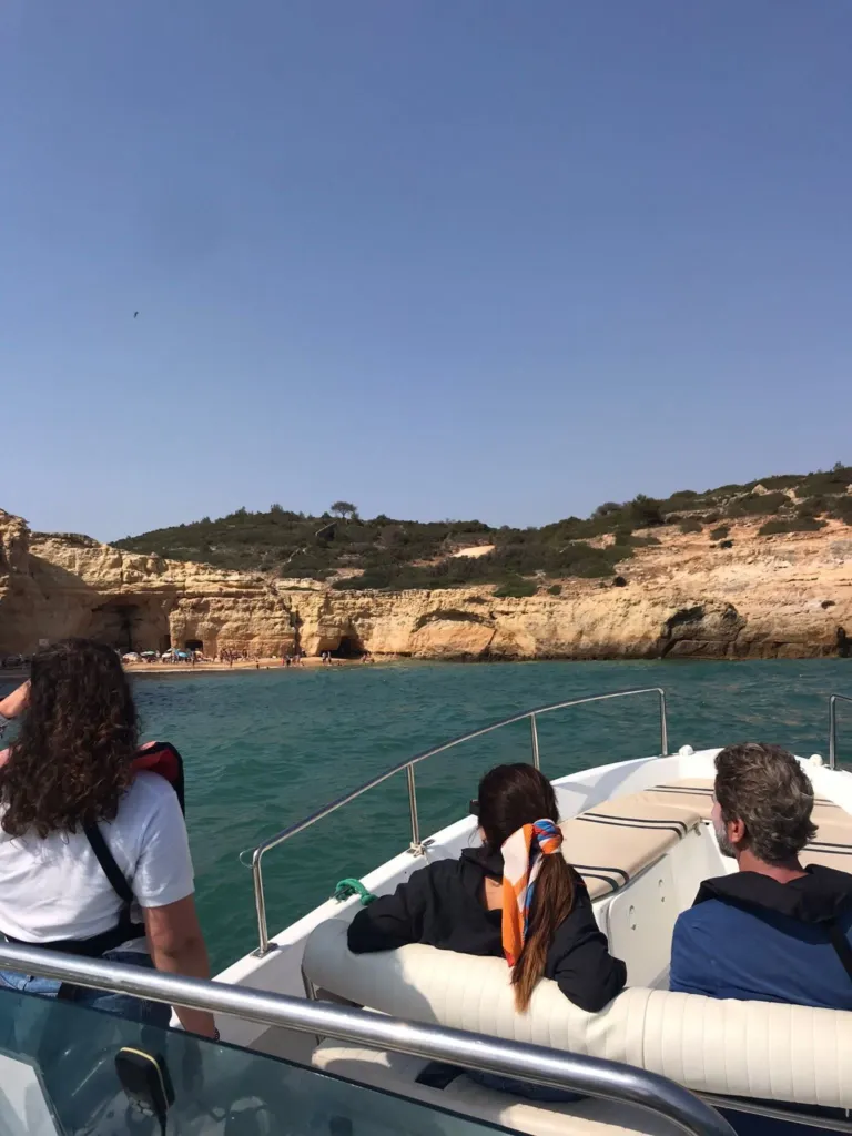Passengers on a boat looking at cliffs along the coast