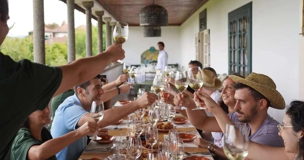 Guests raising glasses of wine at a long table on a veranda