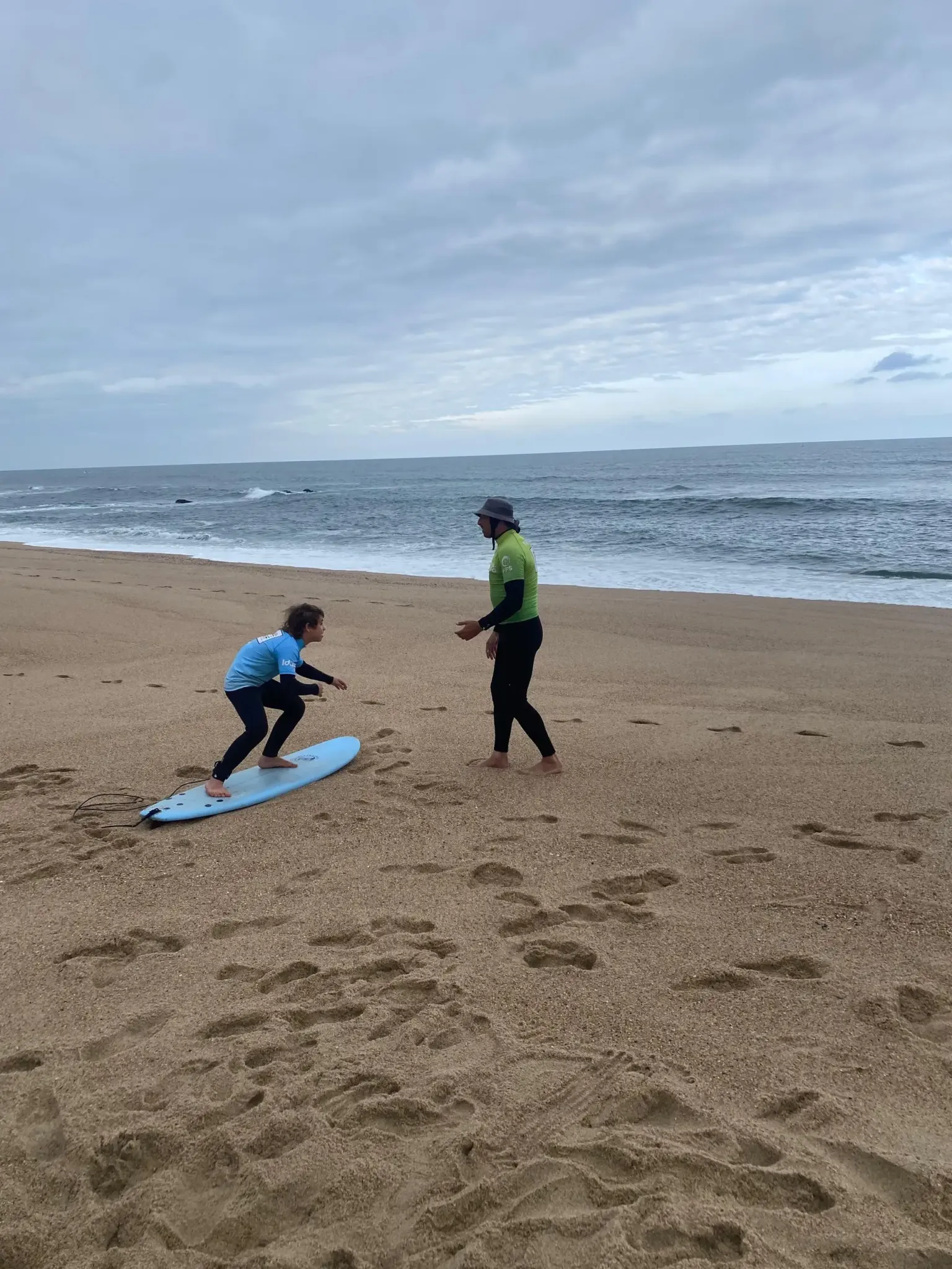 Surf student and instructor practising on a quiet beach