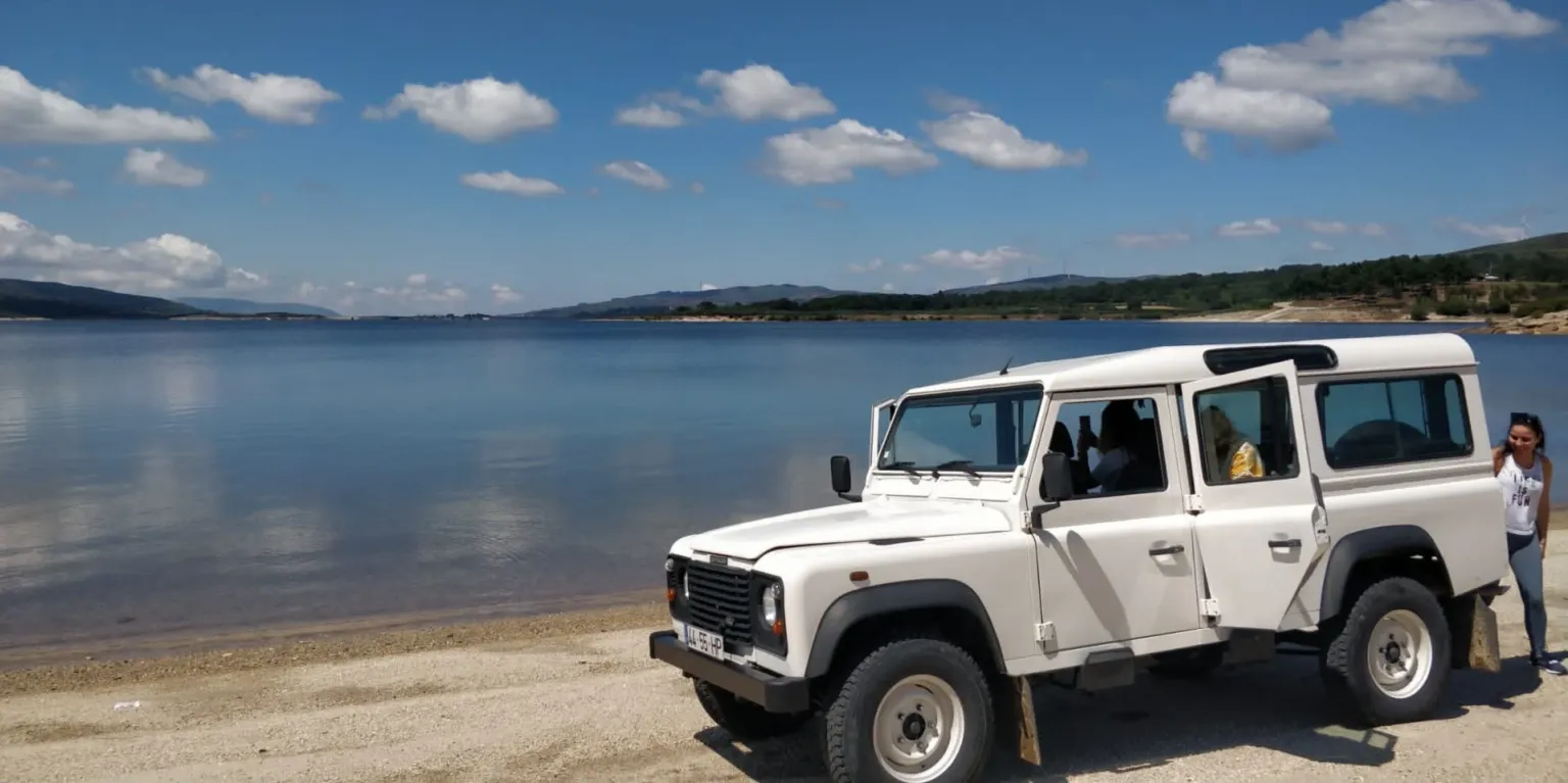 White 4x4 parked on a lakeshore beach