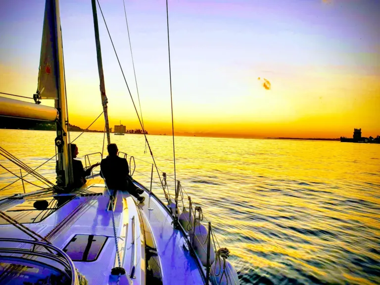 Bow of a sailboat pointing into a golden sunset