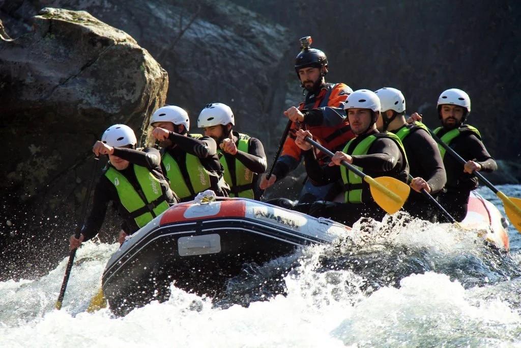 Rafters in helmets paddling through white water