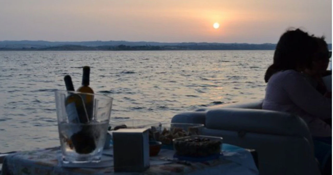 Wine bottle in an ice bucket on a boat table at sunset