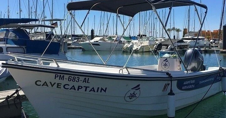 White boat named Cave Captain moored in a marina