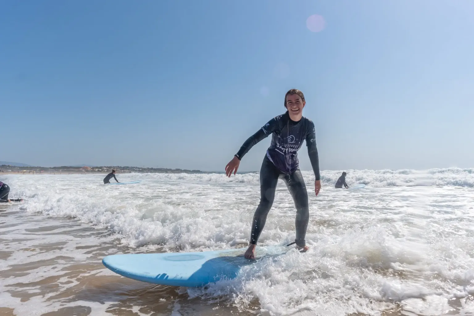 Surfer riding a small wave on a blue board