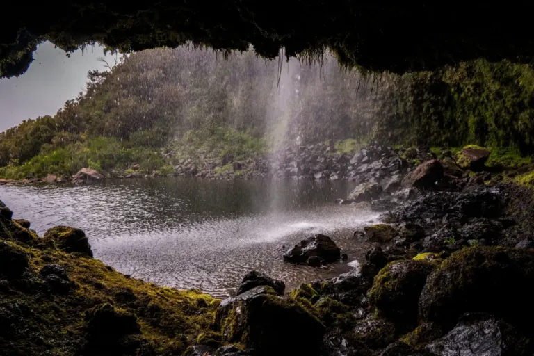 Waterfall seen from inside a cave overlooking a pool