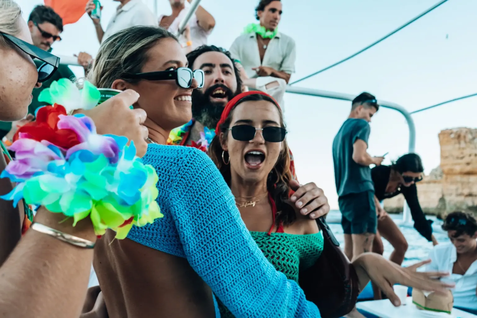 Guests wearing flower garlands partying on a boat deck