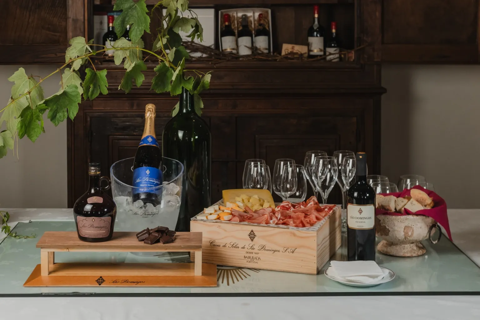 Sparkling wine, wine bottles and a snack platter set out on a cellar table