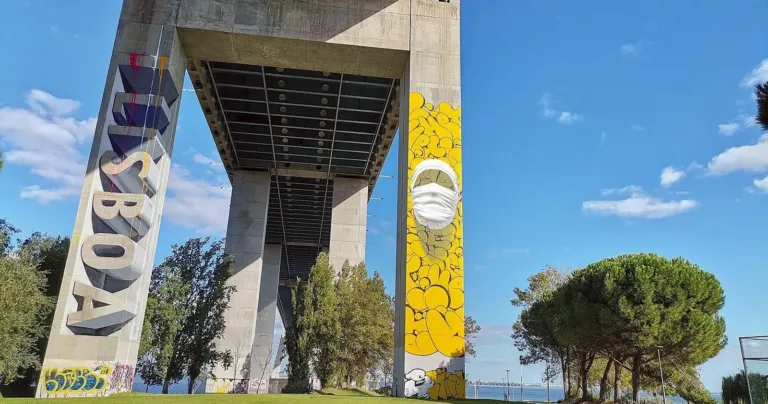 Underside of a motorway bridge, with 'Lisboa' graffiti on a pillar