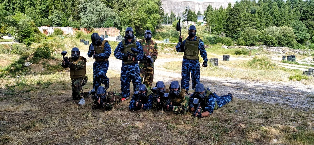 Paintball-Team in blauer Tarnung posiert auf einem Feld
