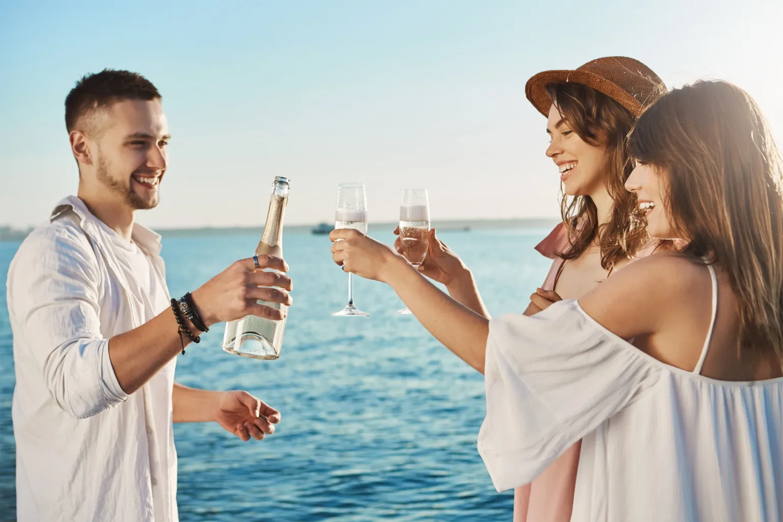 Three people toasting with drinks on a boat