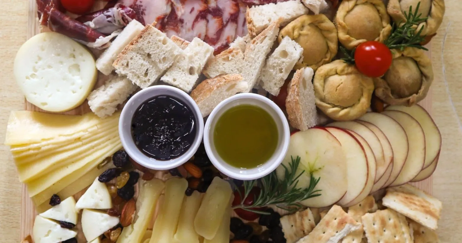 Platter of cheese, bread, preserves and olive oil