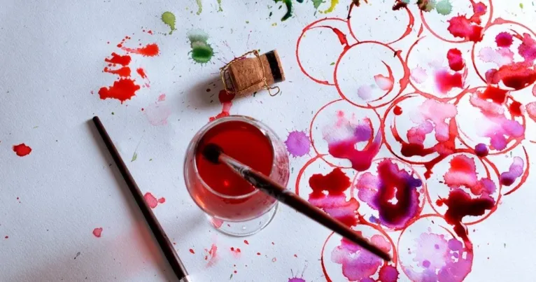 Painting with wine: watercolour-style splashes in red on white paper