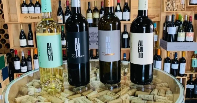 Display of white and red wine bottles on a barrel of corks
