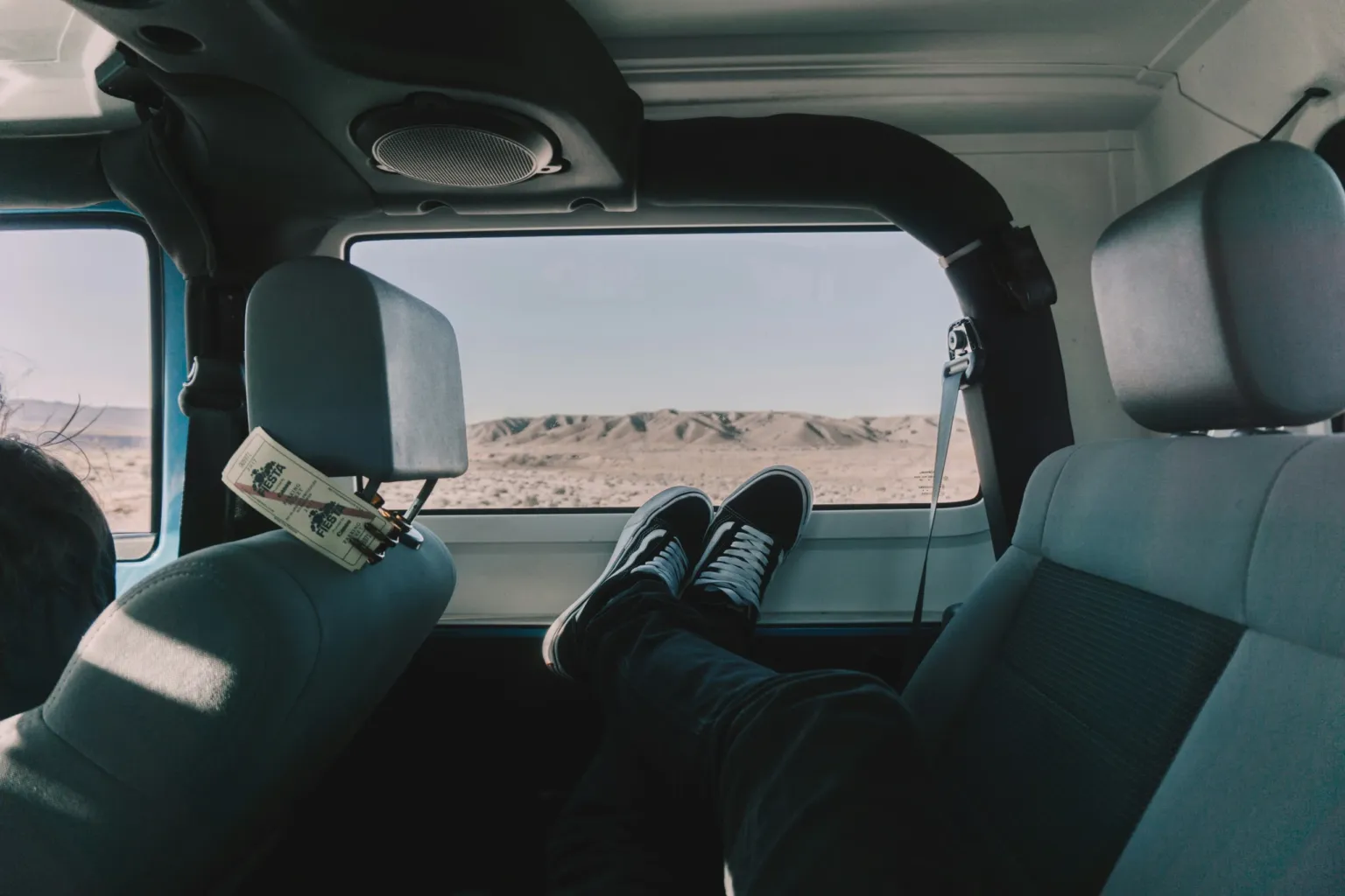 View from inside a 4x4 jeep towards a sandy landscape