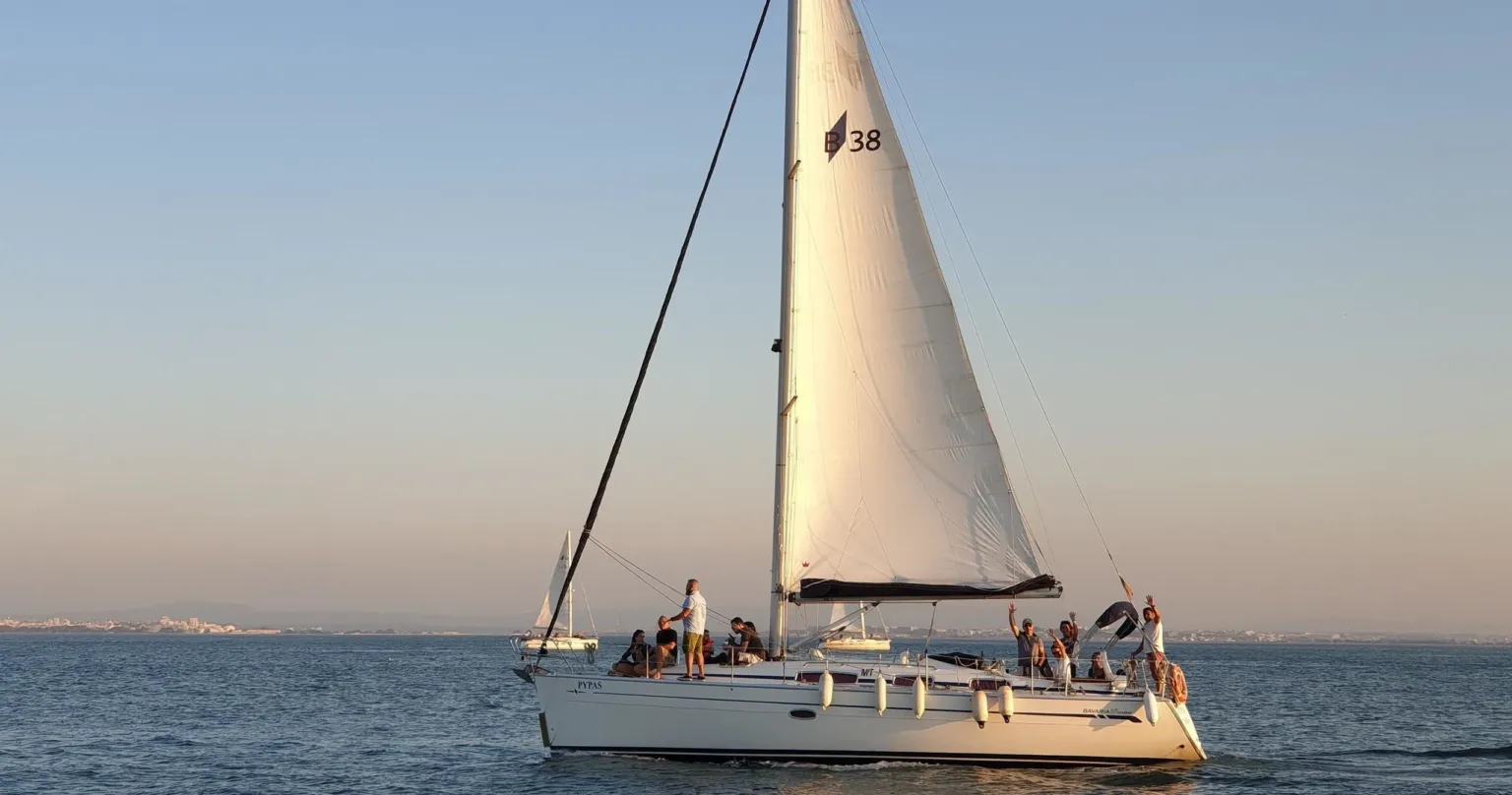 Sailboat with passengers on the river in warm evening light