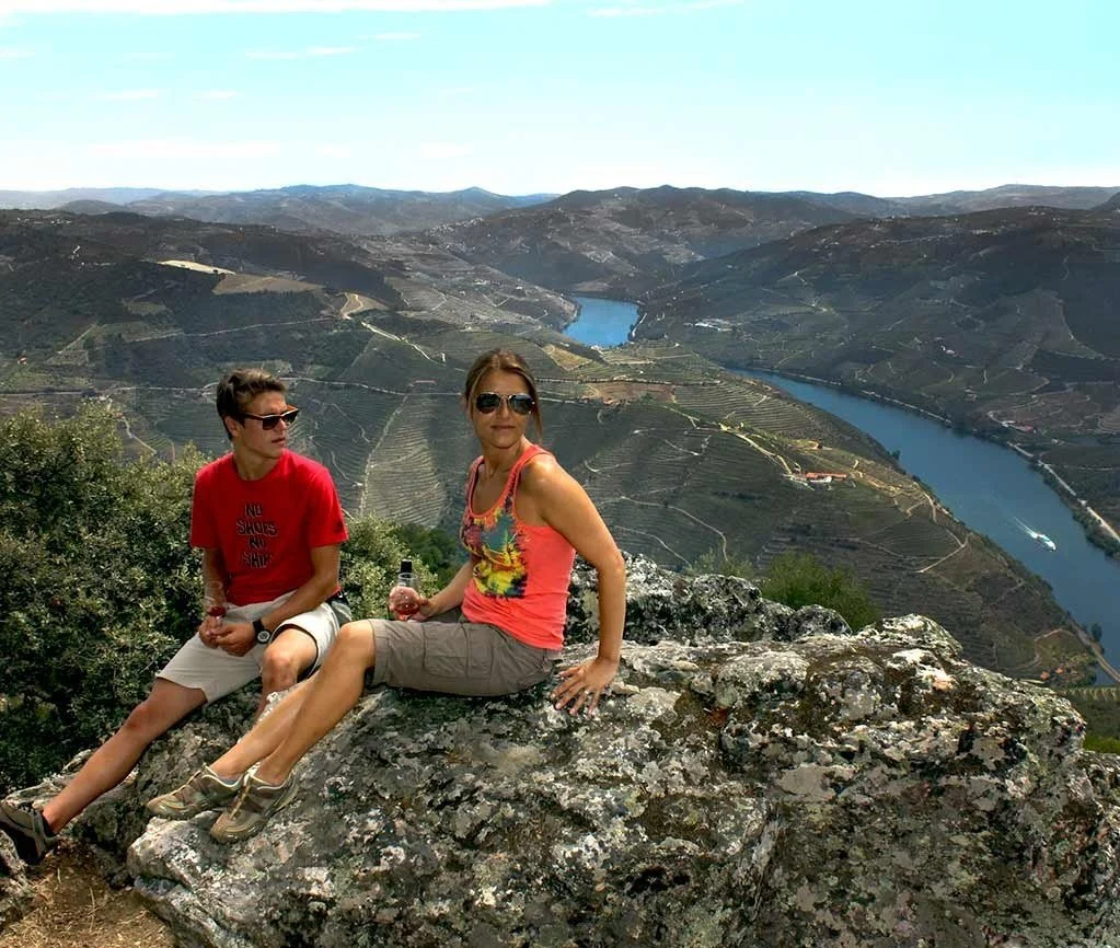 Couple sitting on a rock overlooking a bend of the Douro river