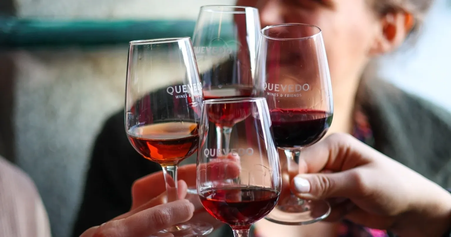 Hands clinking glasses of port at a tasting