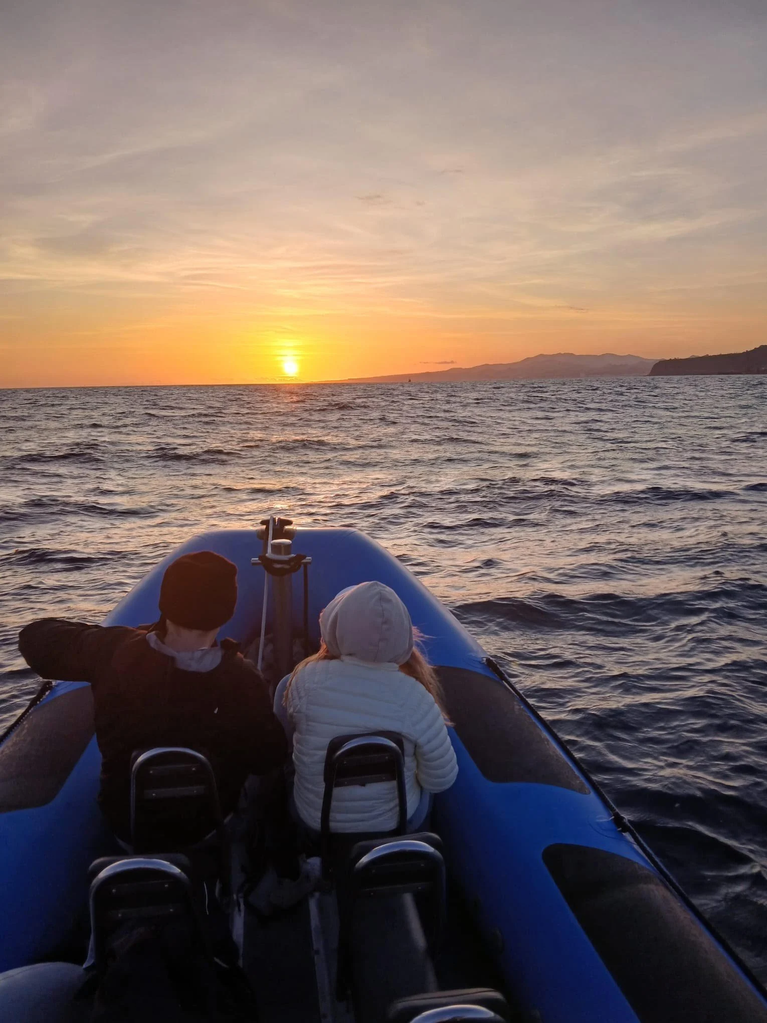 Passengers on an inflatable boat watching the sunset
