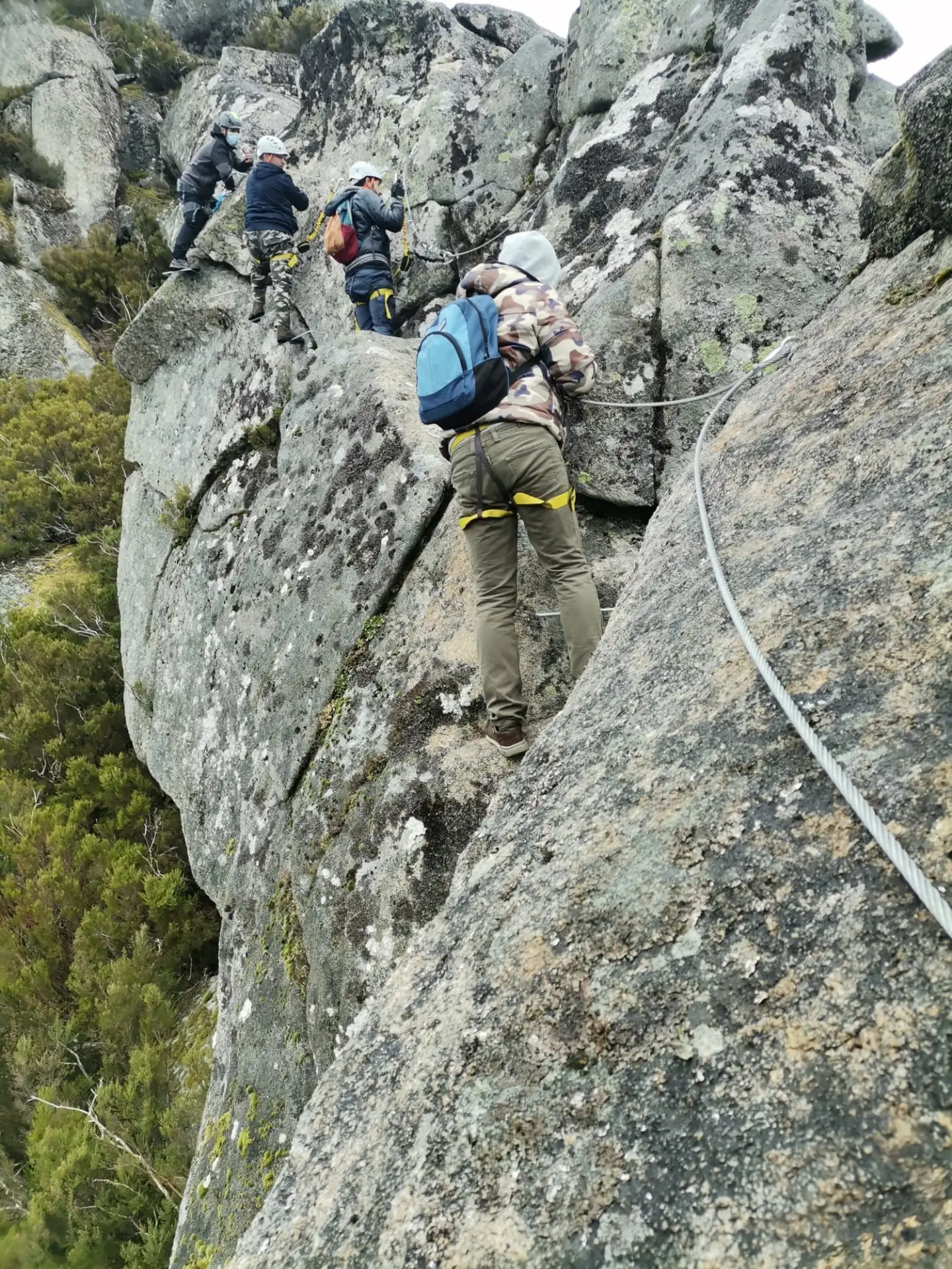 Climber on a rock face using a fixed rope