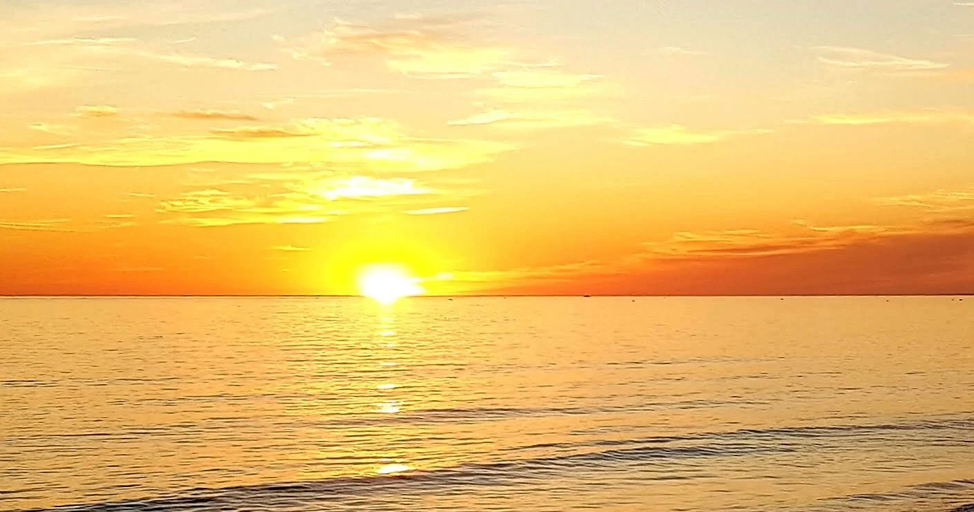 Sun setting over the sea in an orange sky