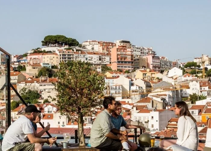 Friends chatting on a terrace overlooking Lisbon's rooftops