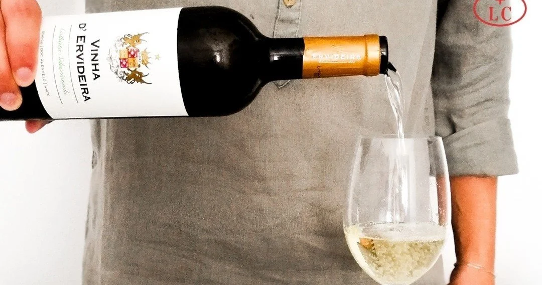 White wine being poured into a glass from a bottle