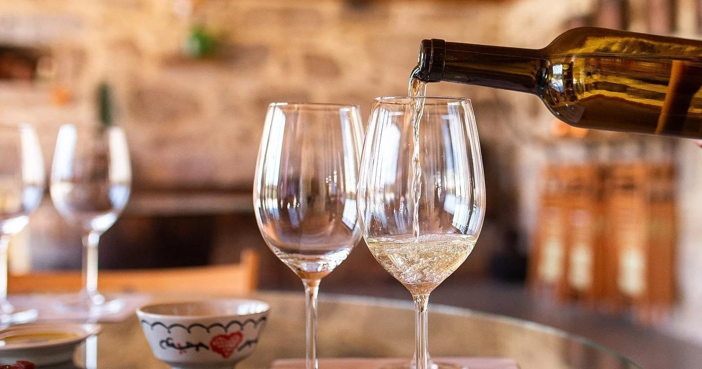 White wine being poured into a glass at a table