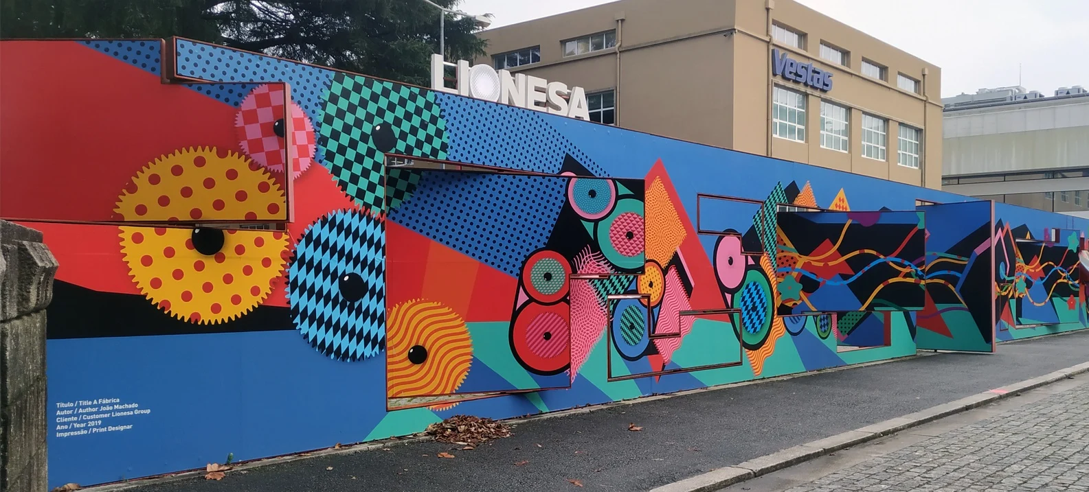 Colourful geometric street-art mural along a wall