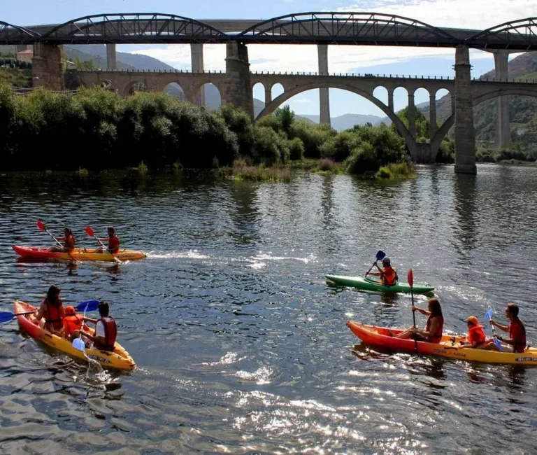 Kayakers paddling beneath railway and road bridges