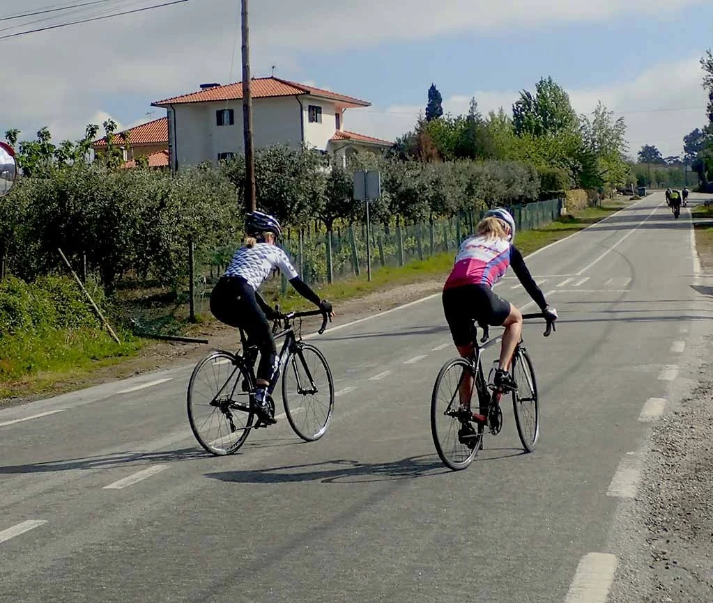 Two road cyclists riding along a quiet country road