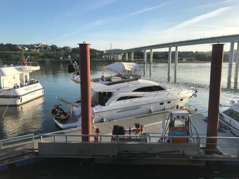 Yacht moored at a floating pontoon beneath a modern bridge