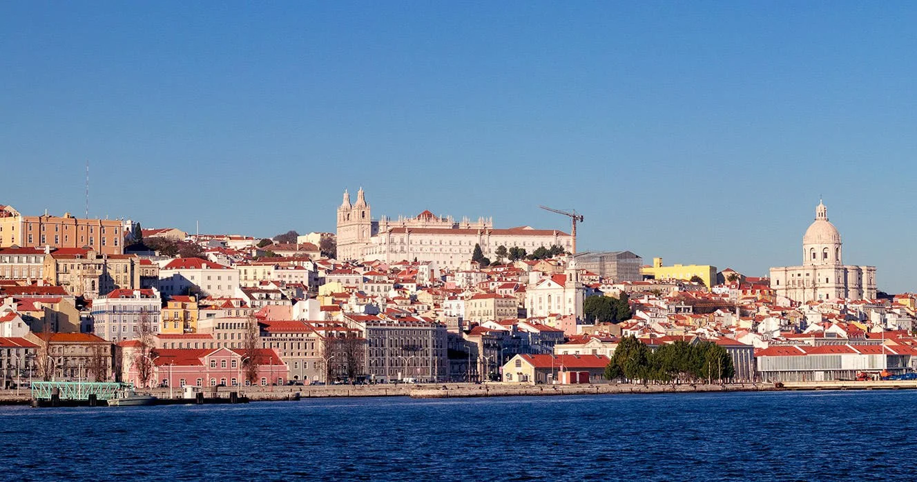 Hillside skyline with domes and red roofs seen across the river