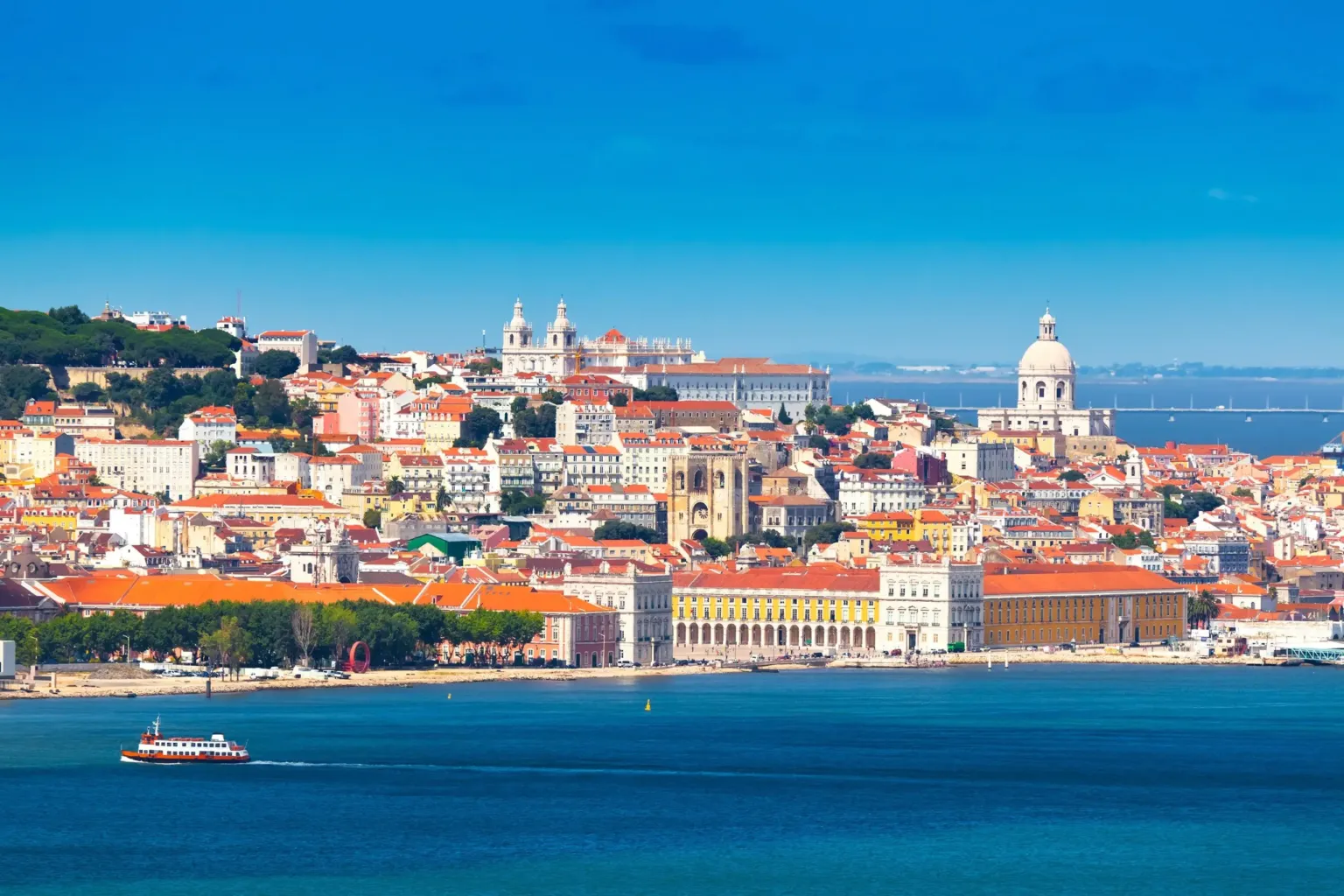 City hillside with domes and red roofs above the waterfront