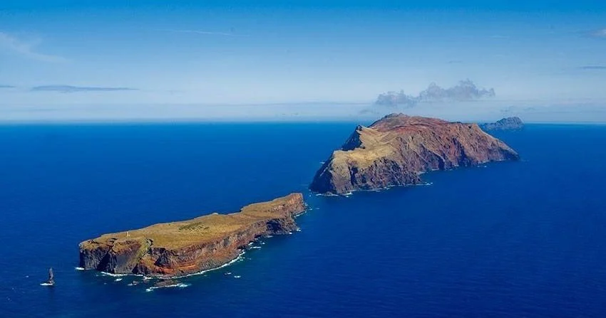 Aerial view of two rocky islands in deep blue sea