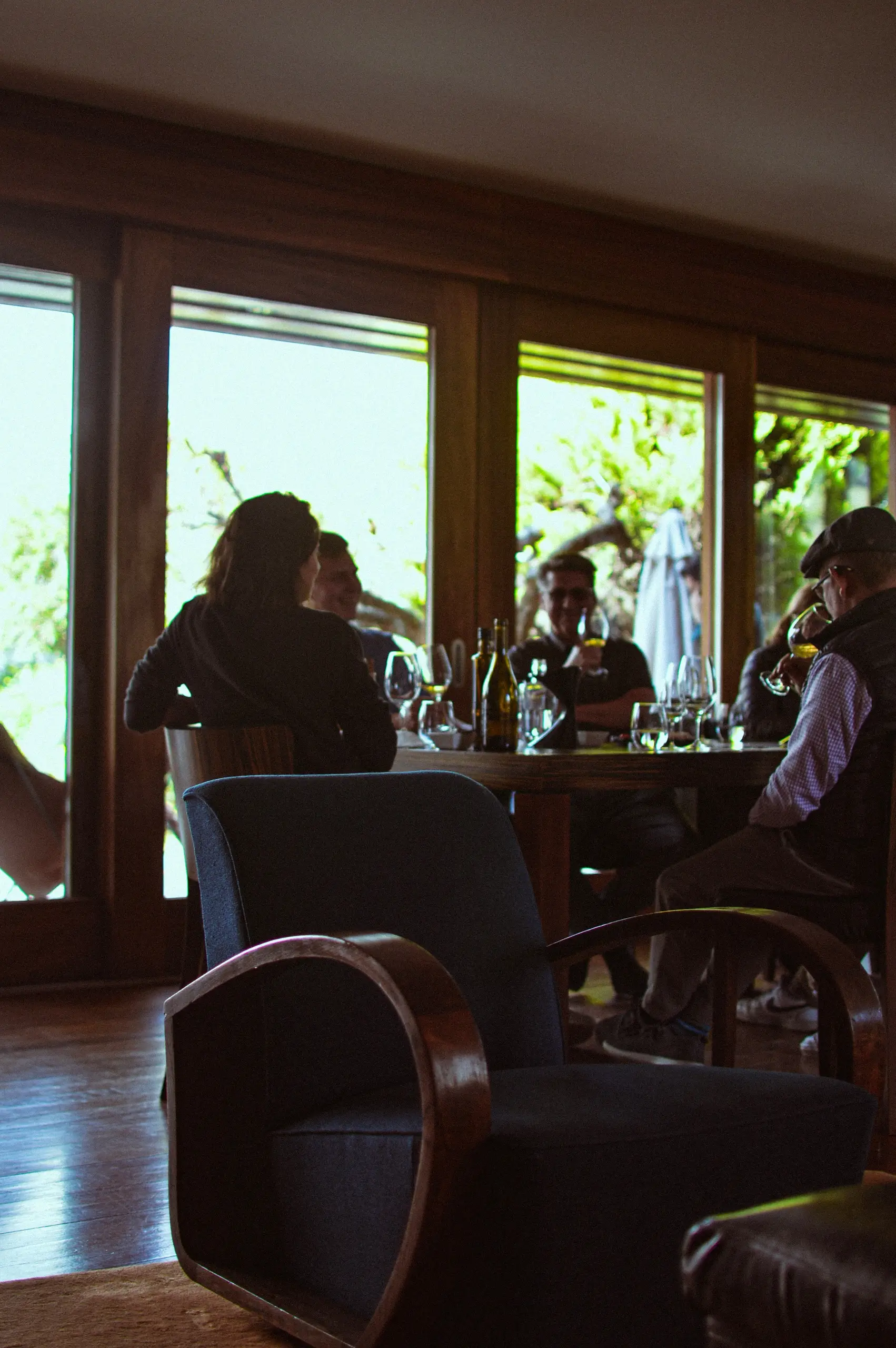 Guests seated by tall windows in a wine bar