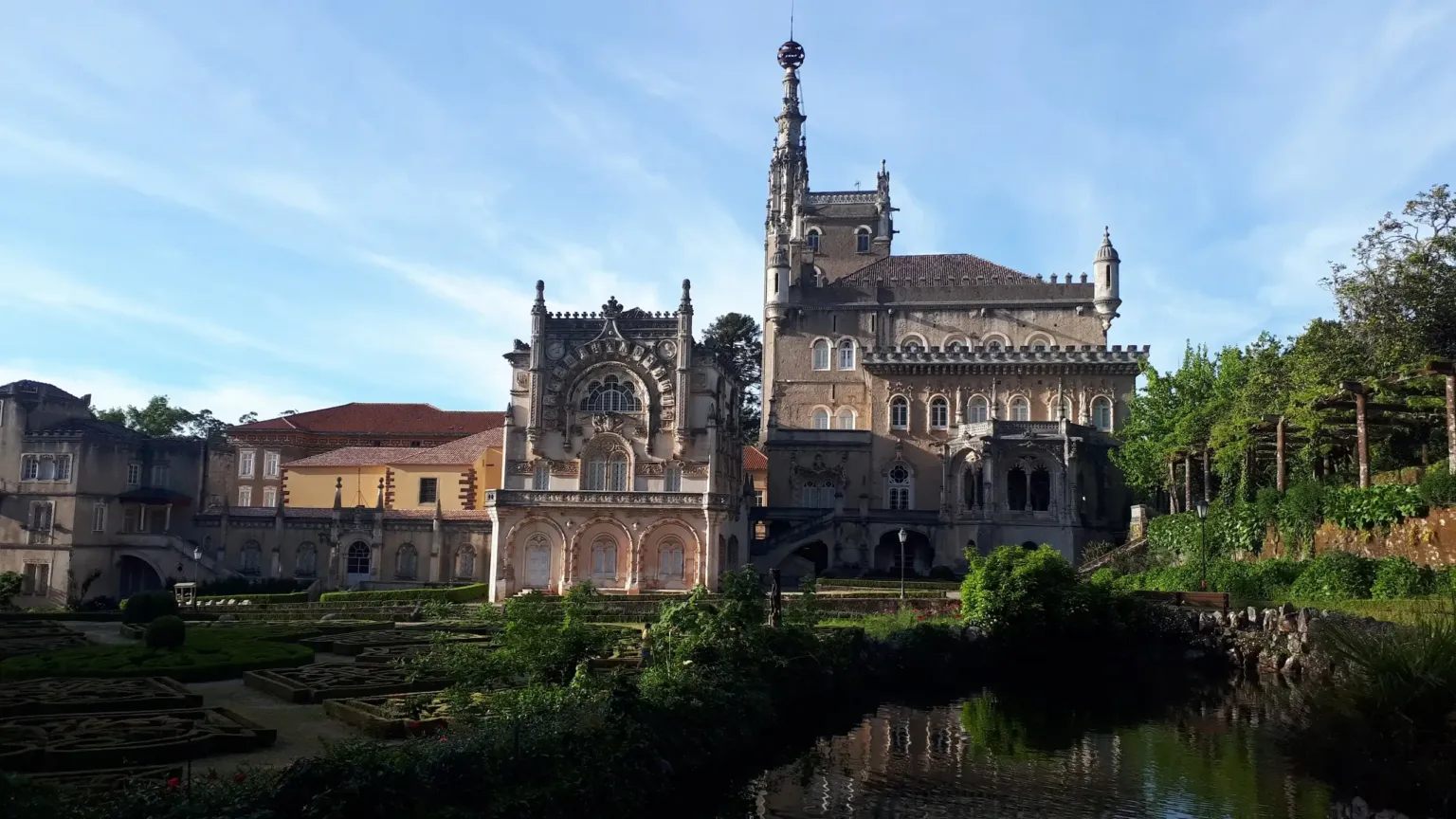 Ornate stone building beside landscaped gardens and a pond