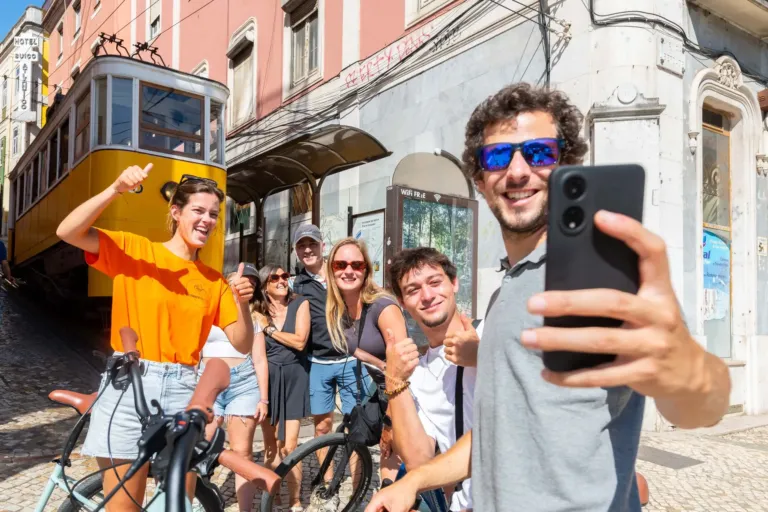 Cheerful group taking a selfie beside a yellow tram