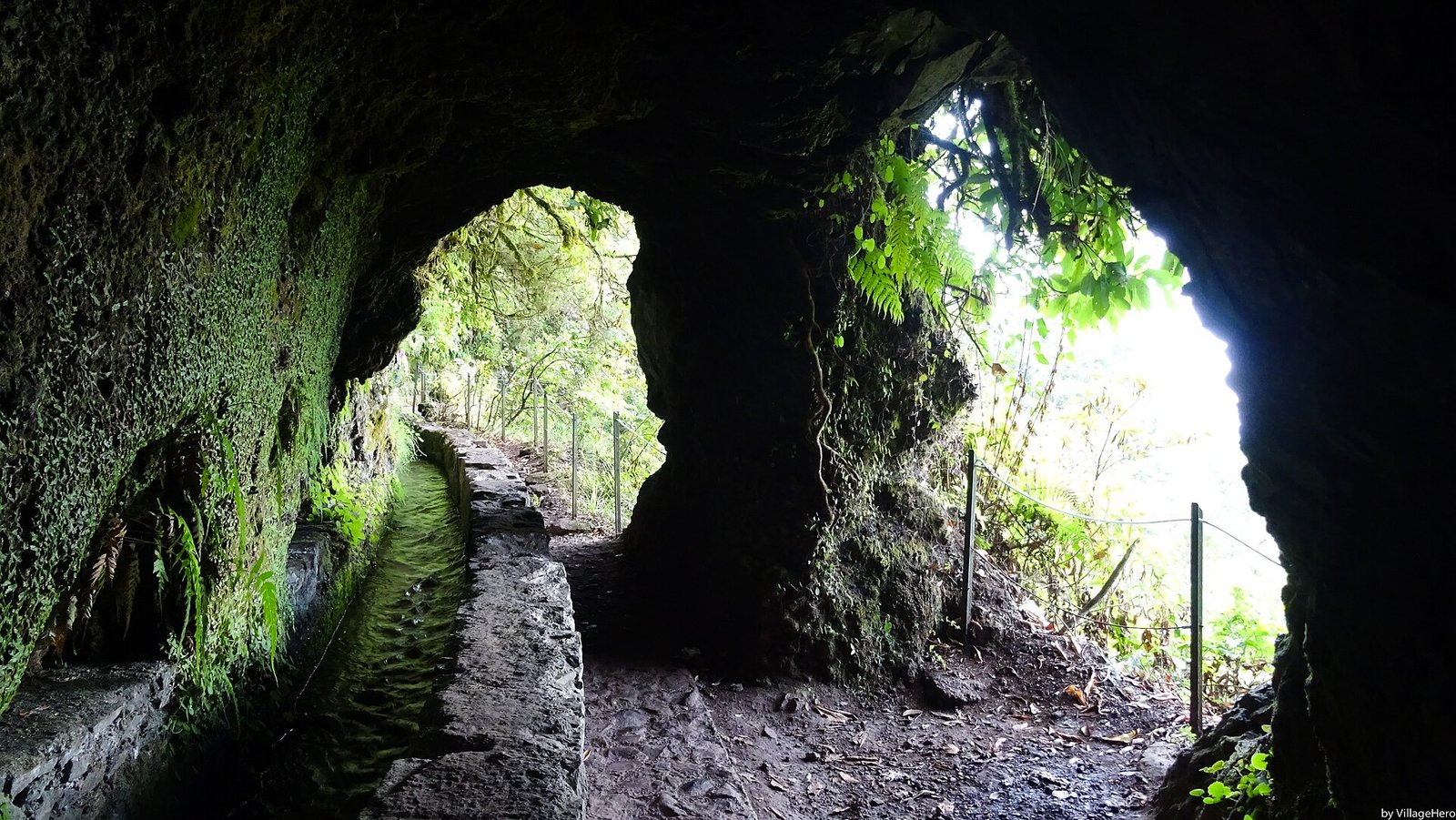 The levada path beneath the green walls of the Caldeirão Verde in Madeira
