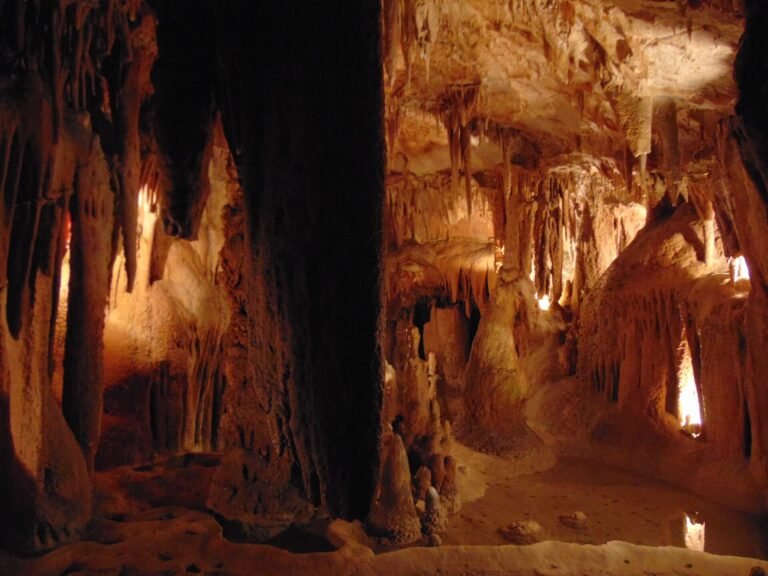 Stalactites and illuminated chambers inside the Grutas de Alvados